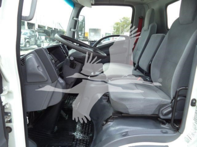 Isuzu NPR HD truck cab interior, front seats and dashboard visible from open door, steering wheel on left, gray upholstery.