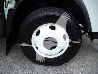 Isuzu NPR HD truck wheel and tire close-up view showing wheel with white hubcap and tire tread.