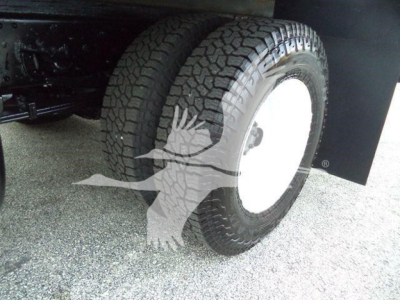 Isuzu NPR HD truck wheel and tire underbody view showing dual rear tires and white wheel hubs.