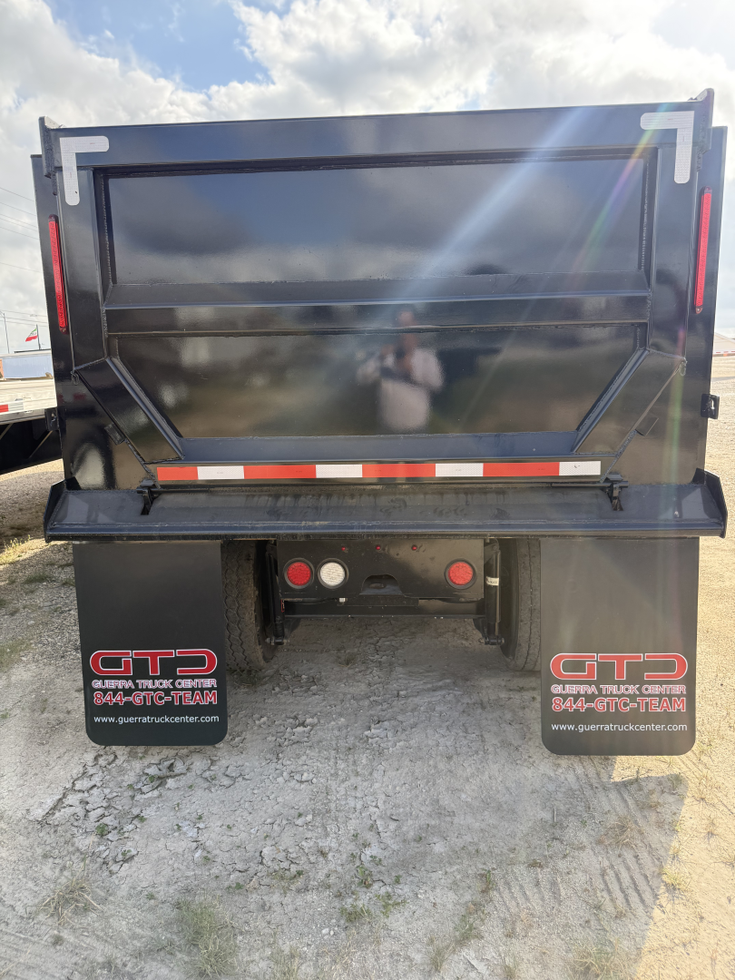 Peterbilt 579 dump truck rear view showing dump bed and mud flaps with GTD branding, taillights, and hydraulic mechanism.