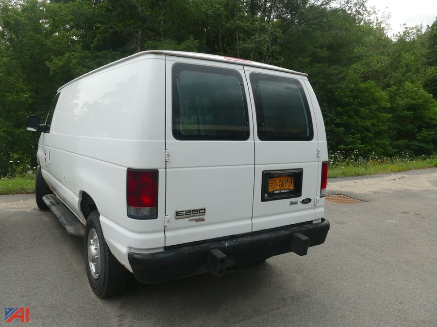 Ford E-250 cargo van rear view showing dual rear doors and NY license plate.