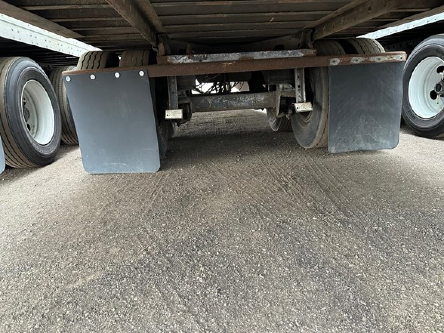 Rear view of a Great Dane Champion trailer undercarriage with mud flaps and dual wheels visible.