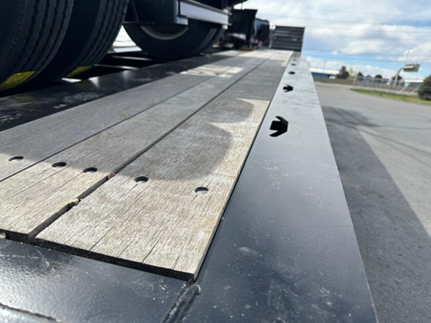 Load King lowboy trailer deck with wooden boards and steel edge, side view showing surface details and fasteners.