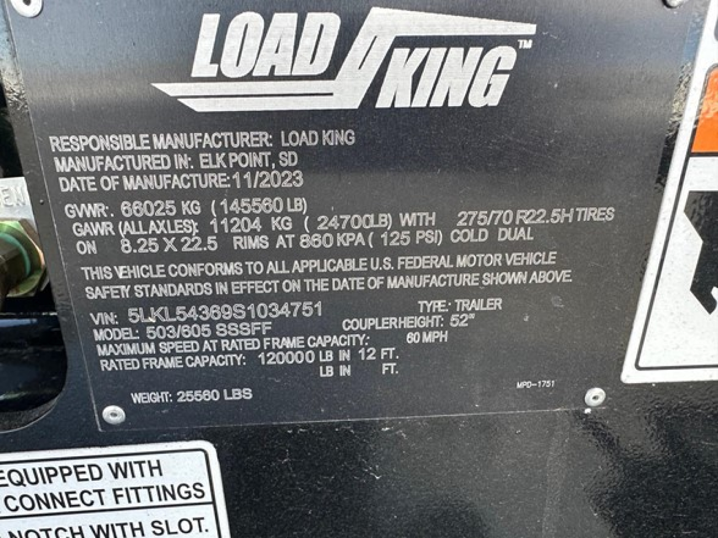 Load King trailer nameplate showing manufacturer, GVWR, GAWR, tire specs and model details on black metal plate.