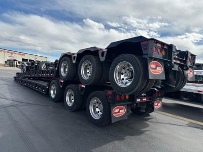 Lowboy trailer stack showing multiple axles and wheels with Load King logo mudflaps.