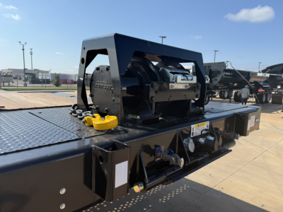 Landoll 455B-53 55 Ton traveling axle lowboy trailer show top deck and winch area with hydraulic rams and safety chain.