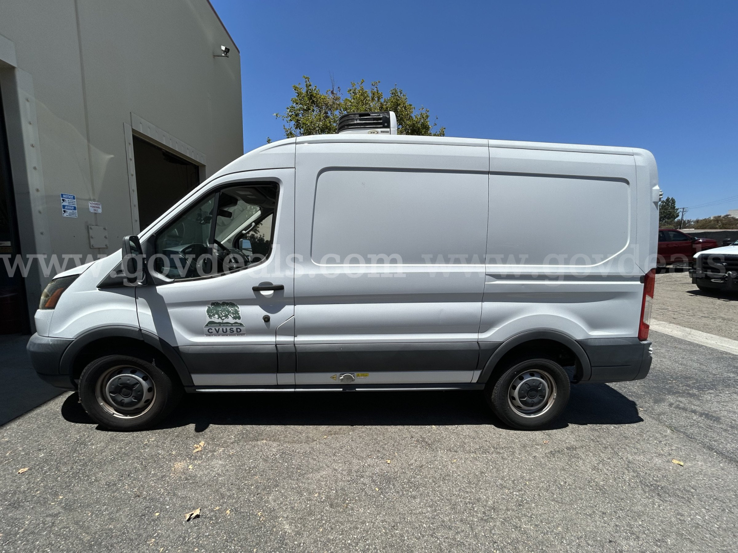 Side view of a white 2017 Ford Transit refrigerated cargo van with a CVRD logo on the front door, no perishables visible, in-service vehicle.