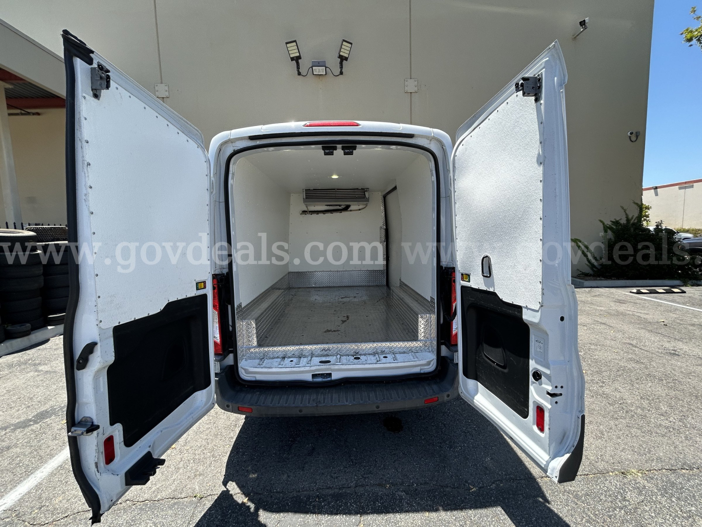 Transit van rear view showing empty refrigerated cargo area with open rear doors and white interior
