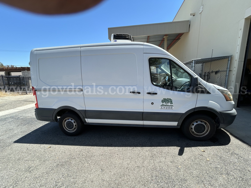 Ford Transit refrigerated cargo van side view showing refrigeration unit on roof and cargo area with logo