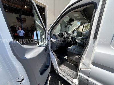Ford Transit interior view showing steering wheel and front seat area with open driver door in a refrigerated truck, VIN visible contextually.