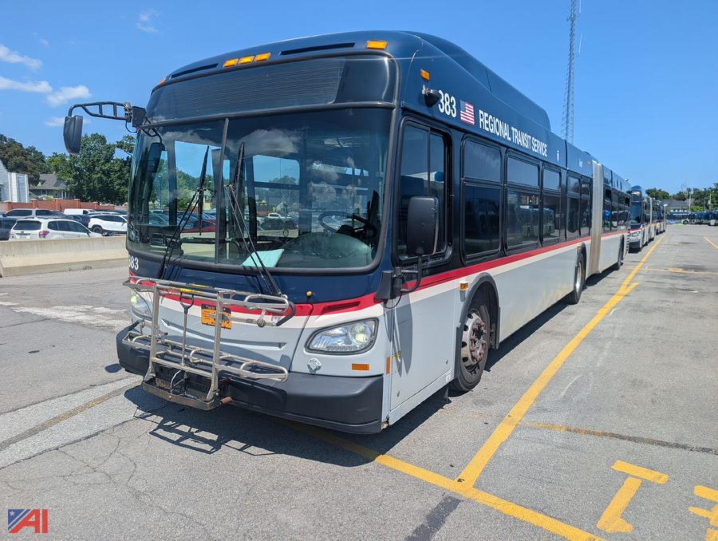 Used 2013 New Flyer XD60 transit bus in a parking lot, front three-quarter view, blue-gray with red stripe, bike rack and large windows visible.
