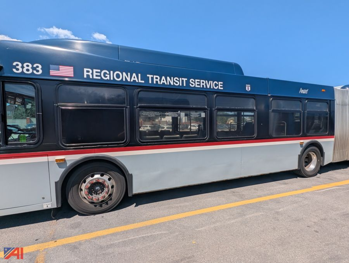 School bus-style transit bus side view showing REGIONAL TRANSIT SERVICE text, fleet number 383, blue upper body with white and red stripe.