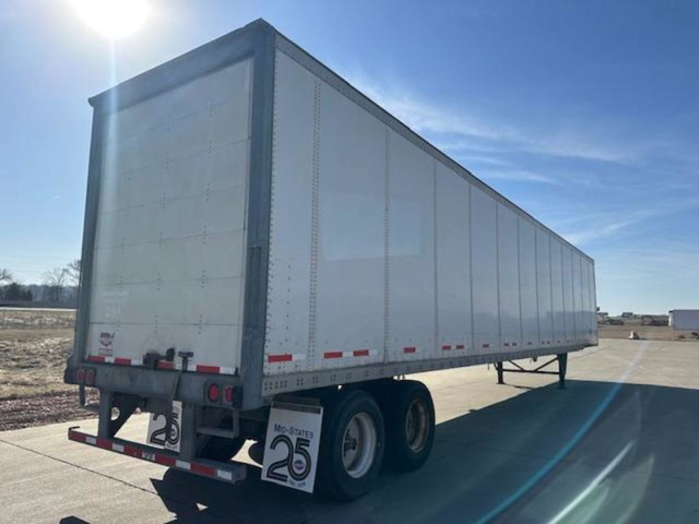 Trailer side view showing 2016 Wabash van with white exterior and dual rear wheels, reflectors, and stock number U90826 on sign. VIN 1JJV532D2GL908619 not visible but listed.