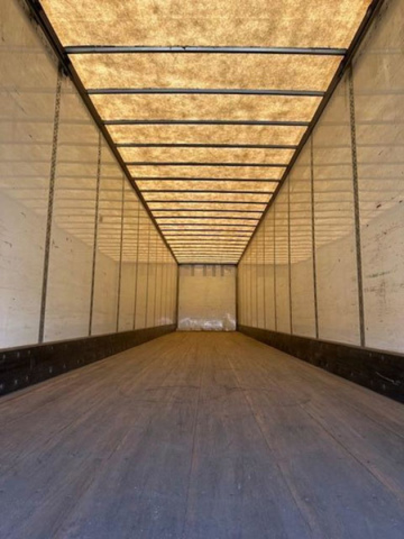 Interior of a 2016 Wabash van trailer showing empty cargo area with wooden roof support beams and side walls.