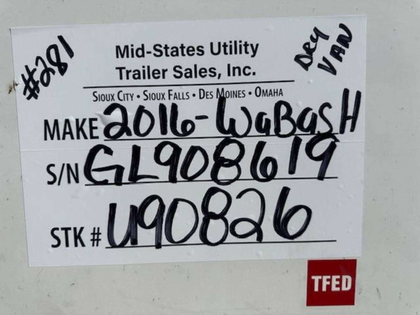 Sign on a used trailer with handwritten inventory details: makes label 'Mid-States Utility Trailer Sales, Inc.' and entries 'Make 2016-Wabash', S/N GL908619, STK # U90826, TFED note, handwritten 'Deep Van'