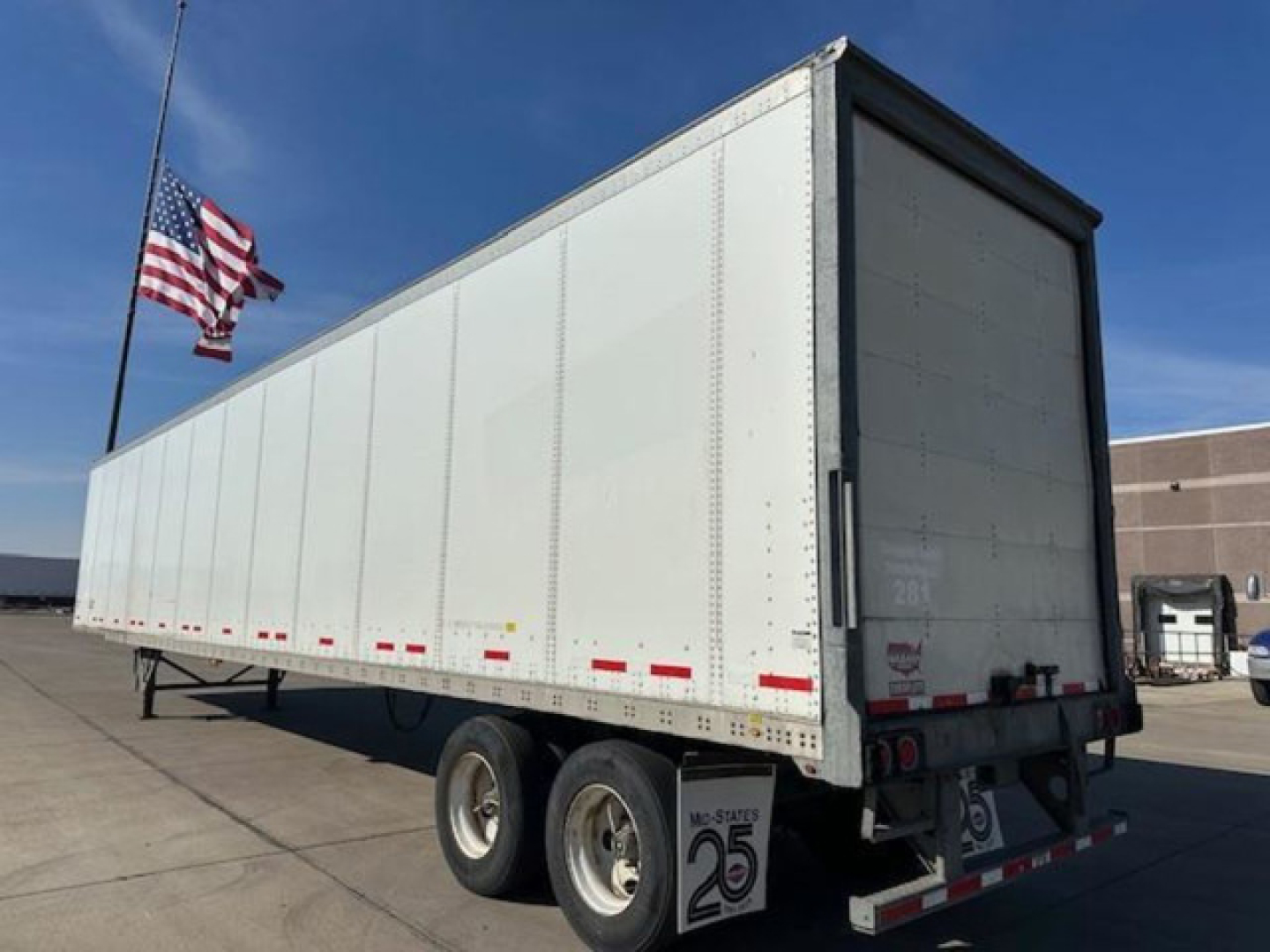 Trailer side and rear view of a white 2016 Wabash van trailer with triple axle, stock number U90826, VIN 1JJV532D2GL908619, American flag visible.