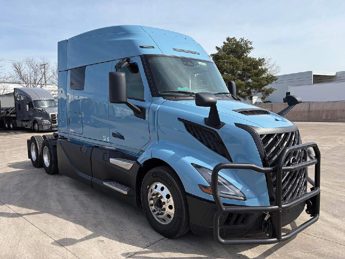 Volvo VNL 840 tractor in blue, front-right view showing grille guard, side mirrors, aerodynamic cab, and dual rear axles.
