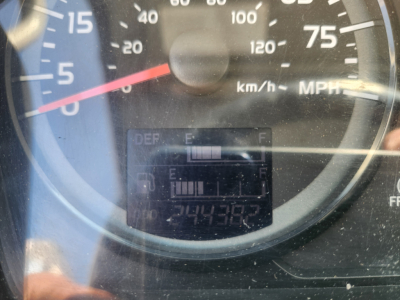 Dashboard gauge cluster showing speedometer up to 75 mph and 120 km/h, with an odometer reading and DEF/ E F bars, and a rectangular display with digits. The text visible includes DEF E F, 244382? digits, and surrounding scale markings.