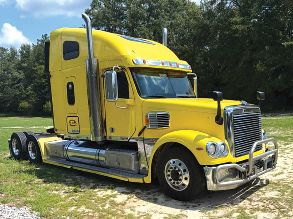 Yellow Freightliner Coronado 2016 tractor-trailer truck, front/right angle with sleeper cabin, chrome bumper, large grille, dual exhaust stacks, and six wheels visible.