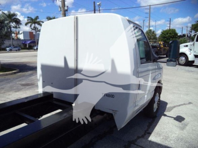 Ford E-450 cargo van rear/side view showing back of body and cargo area with hitch; exterior is white.