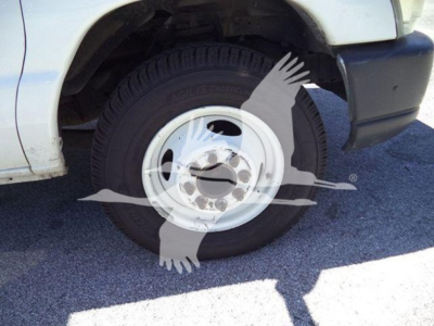 Ford E450 truck wheel and front fender showing tire and rim with partial bumper.