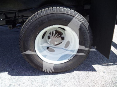 Ford E-Series van/mini-bus wheel and tire with white steel rim on front axle.