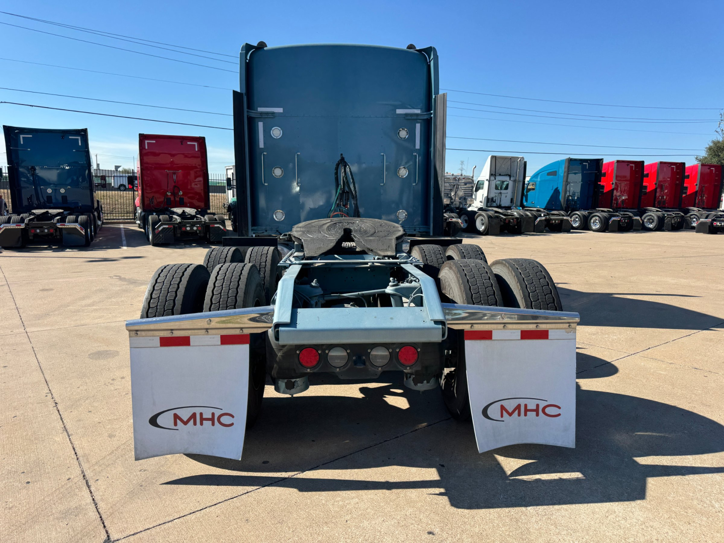 Kenworth W900L rear view showing chassis and dual rear axles with mud flaps labeled MHC.