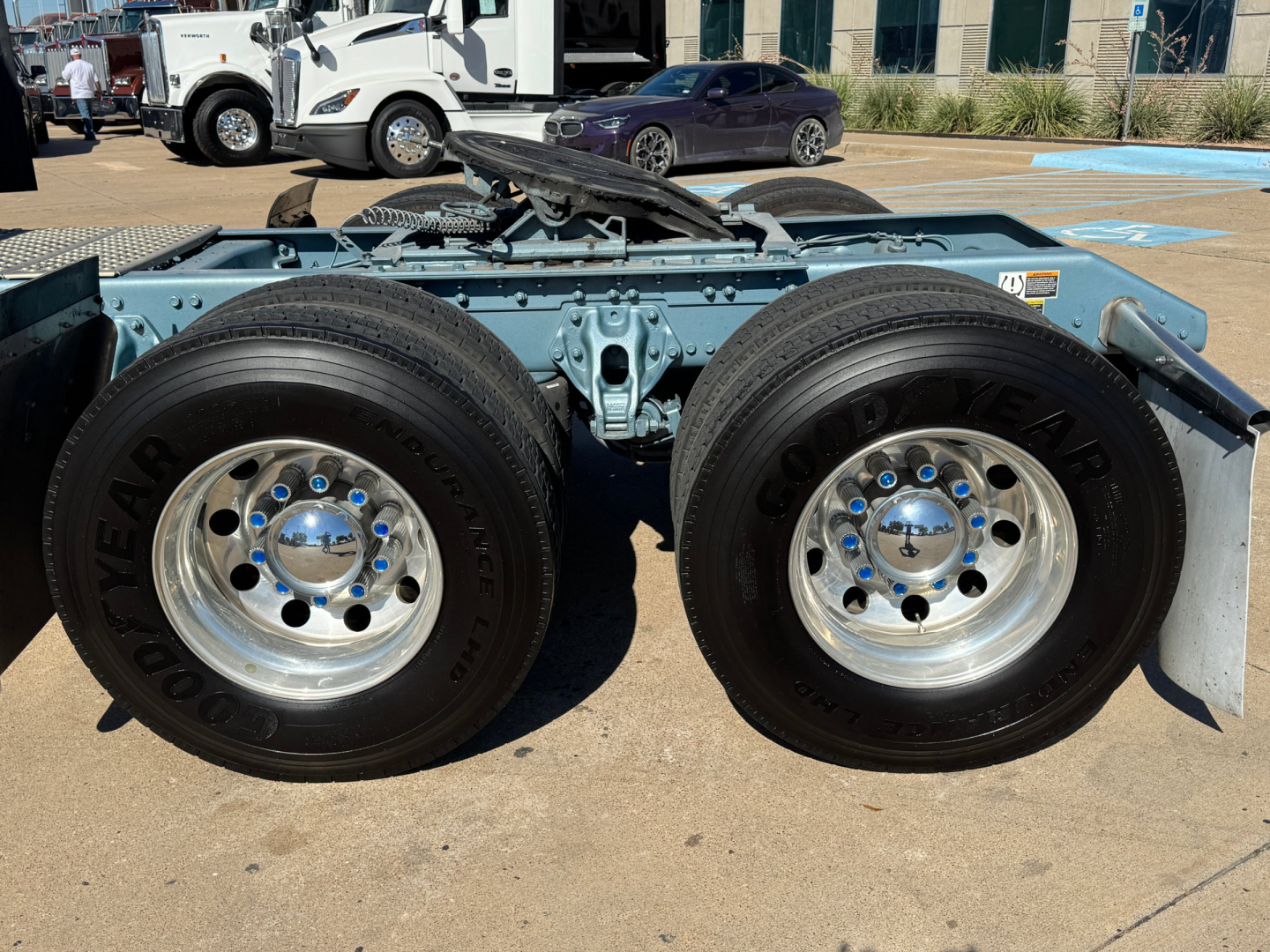 Twin rear wheels on the Kenworth W900L chassis showing Goodyear tires and polished rims with light blue undercarriage.