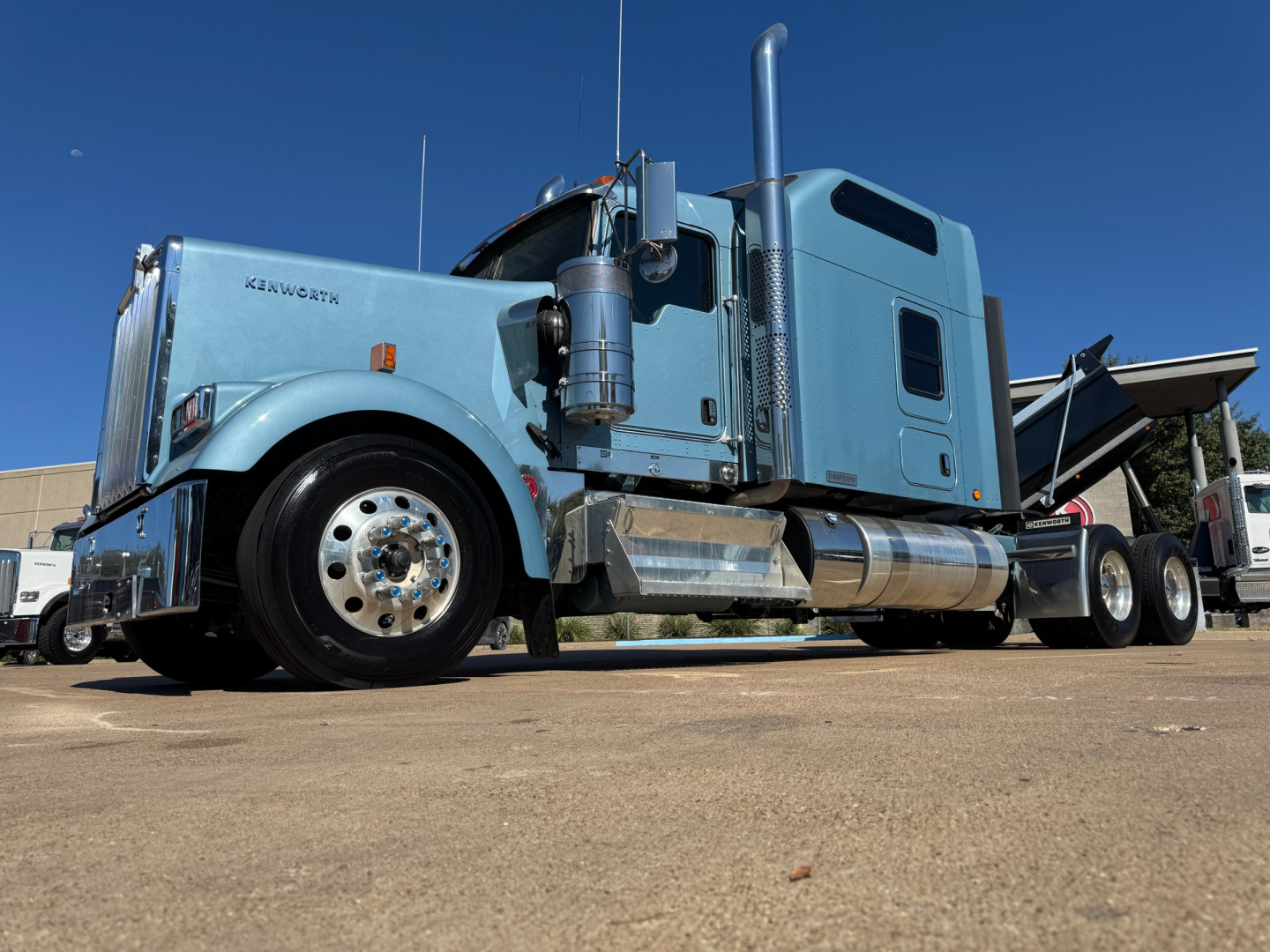 Kenworth W900L conventional sleeper truck side view showing cab, fuel tanks, and chrome steps.
