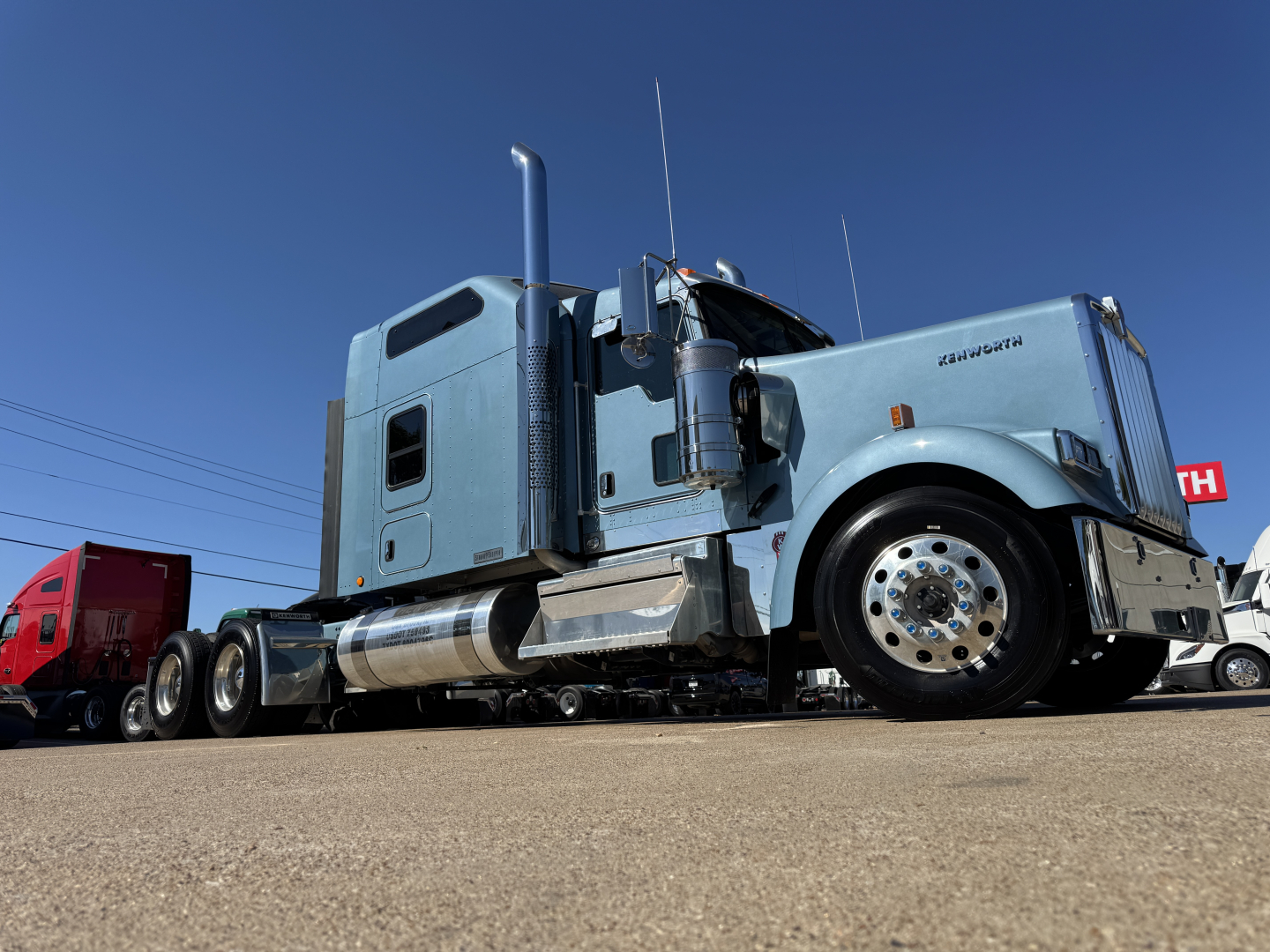 Kenworth W900L conventional sleeper truck, light blue cab, chrome exhaust and fuel tanks, front wheel, side view