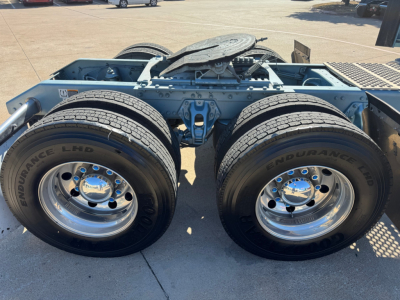 Kenworth W900L truck chassis showing dual rear tandem wheels and fifth wheel with exposed frame rails.
