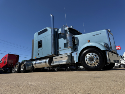 Kenworth W900L conventional sleeper truck, light blue cab, chrome exhaust and fuel tanks, front wheel, side view