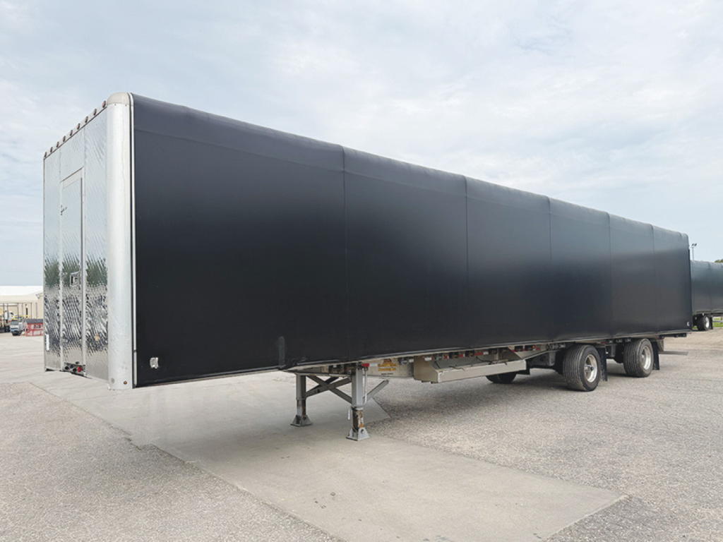 Doonan aluminum curtainside flatbed trailer shown side view with black curtain sides and silver front end.