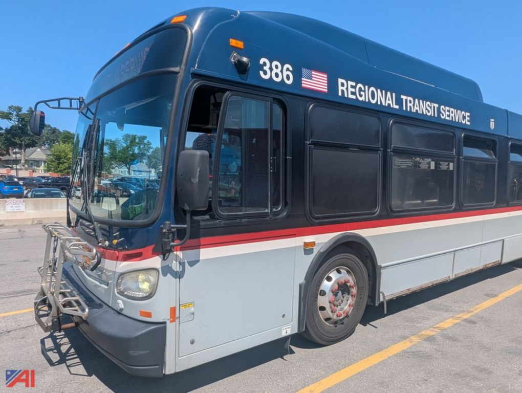 Bus side view showing 2013 New Flyer XD60 transit bus with Regional Transit Service livery, blue upper, white lower, red stripe, front bike rack, number 386, American flag decal.