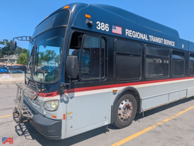 Bus side view showing 2013 New Flyer XD60 transit bus with Regional Transit Service livery, blue upper, white lower, red stripe, front bike rack, number 386, American flag decal.