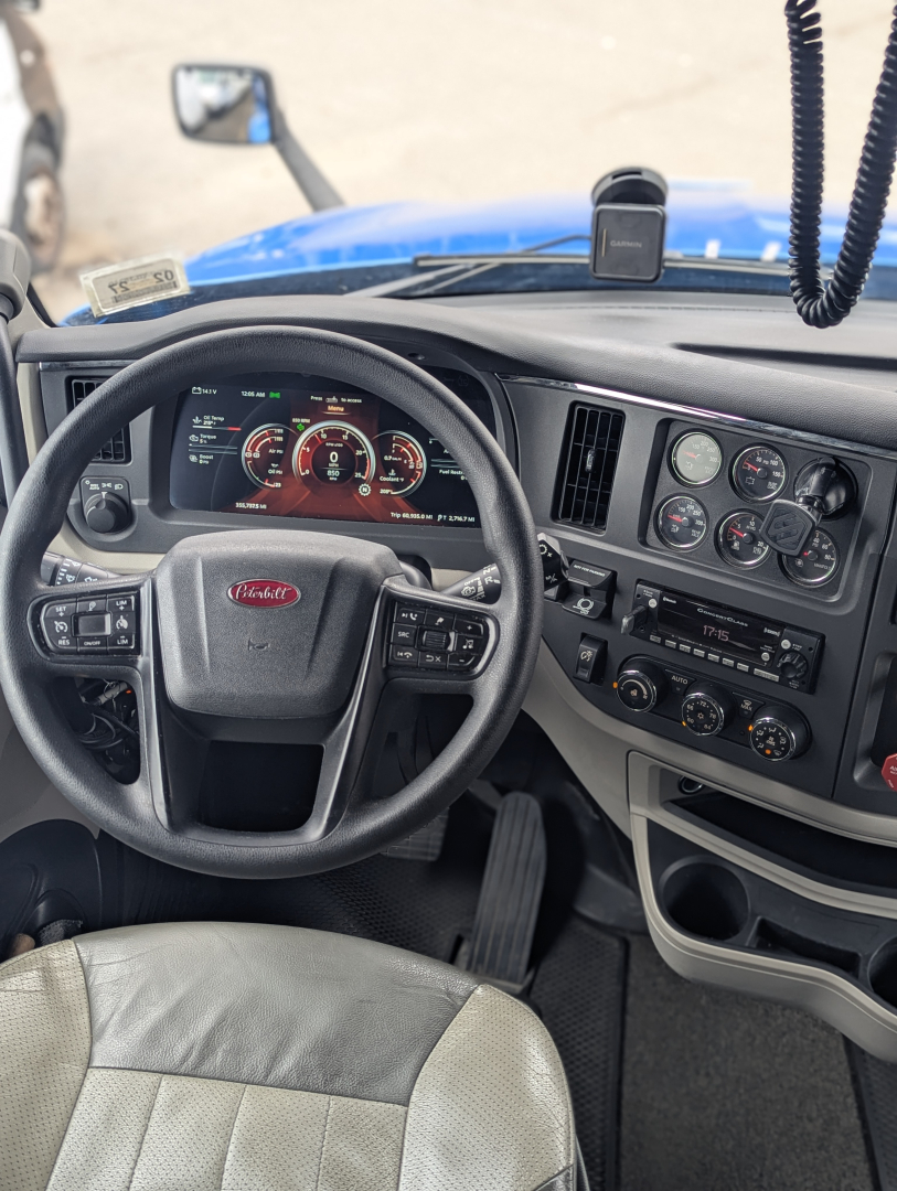 Peterbilt 579 cab interior showing steering wheel, dashboard gauges, and center control panel.