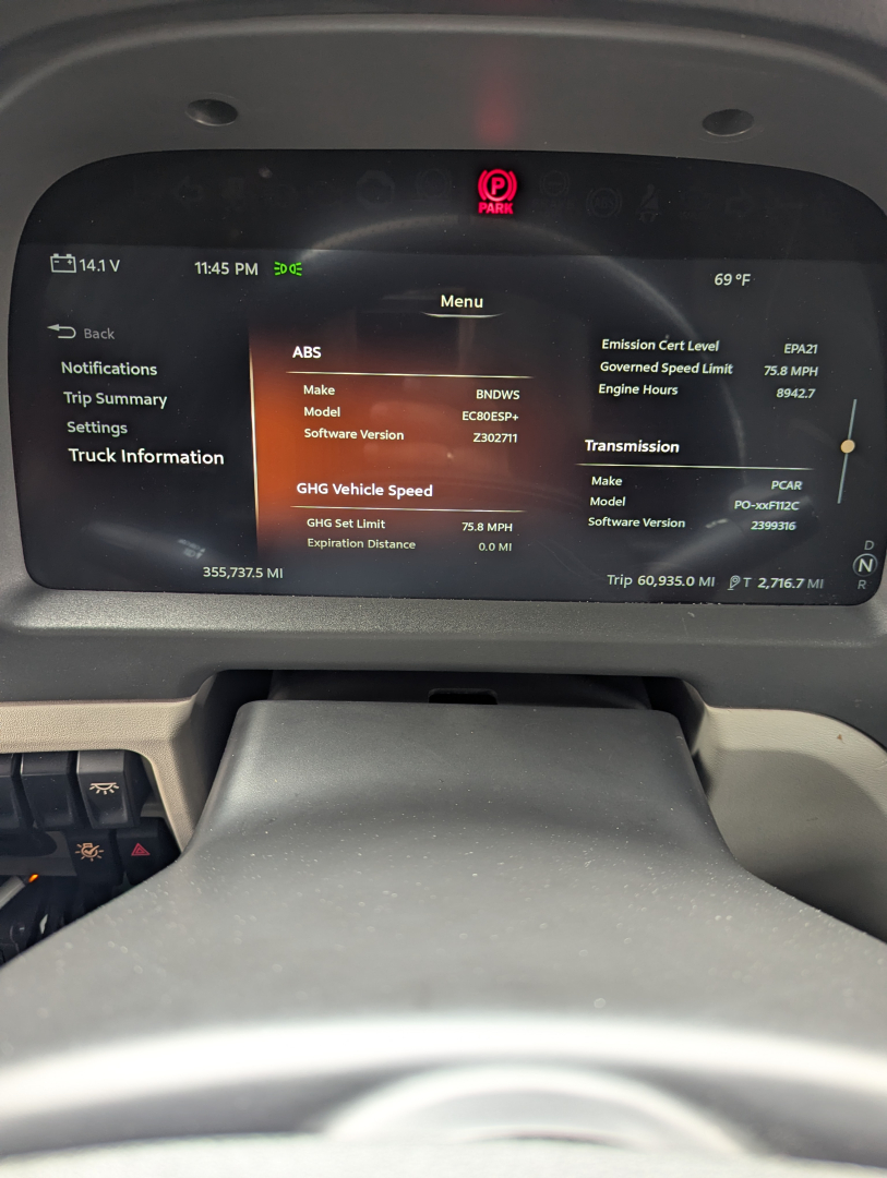 Truck cab dashboard display showing ABS, engine hours, and GHS vehicle speed; digital instrument panel with various system readouts.