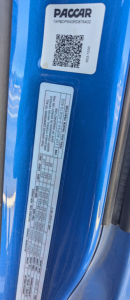 Peterbilt 579 door jamb/bumper area showing Paccar branding label and vehicle specs sticker.