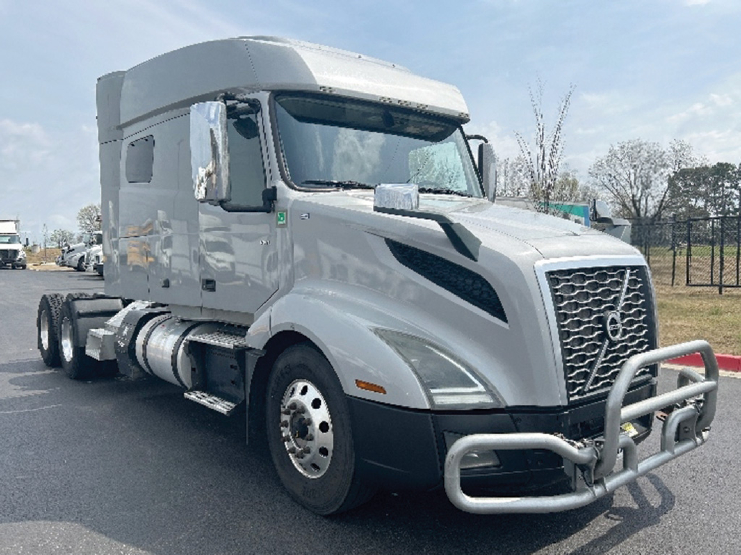 Truck image: 2020 Volvo VNL 740 conventional sleeper, gray/metallic, front chrome grille, bull bar, dual rear axles, large side mirrors, fuel tanks under cab.