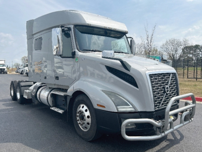 Truck image: 2020 Volvo VNL 740 conventional sleeper, gray/metallic, front chrome grille, bull bar, dual rear axles, large side mirrors, fuel tanks under cab.