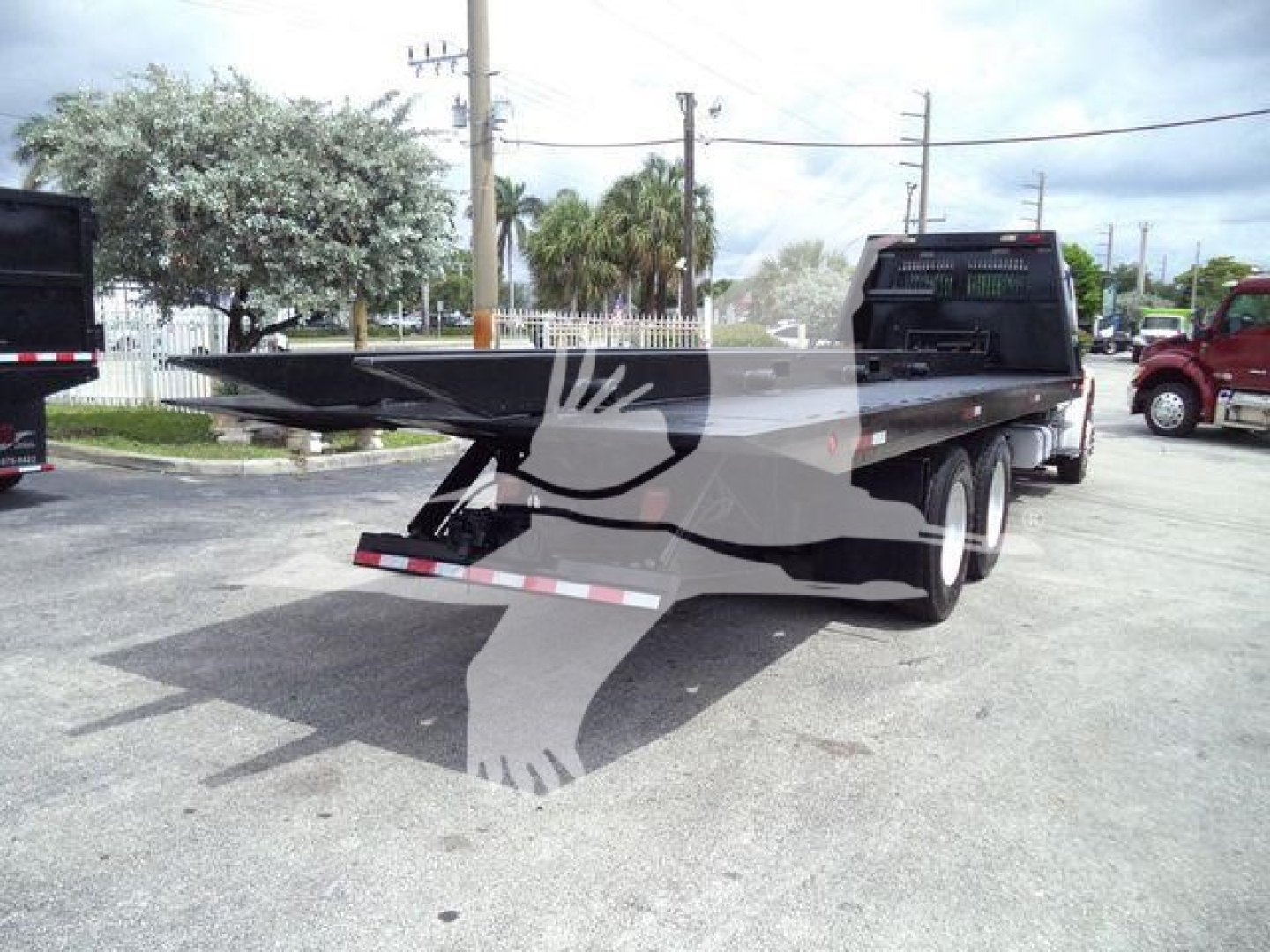 Truck bed of a Freightliner M2 106 roll-off truck showing flatbed and rear dual wheels.