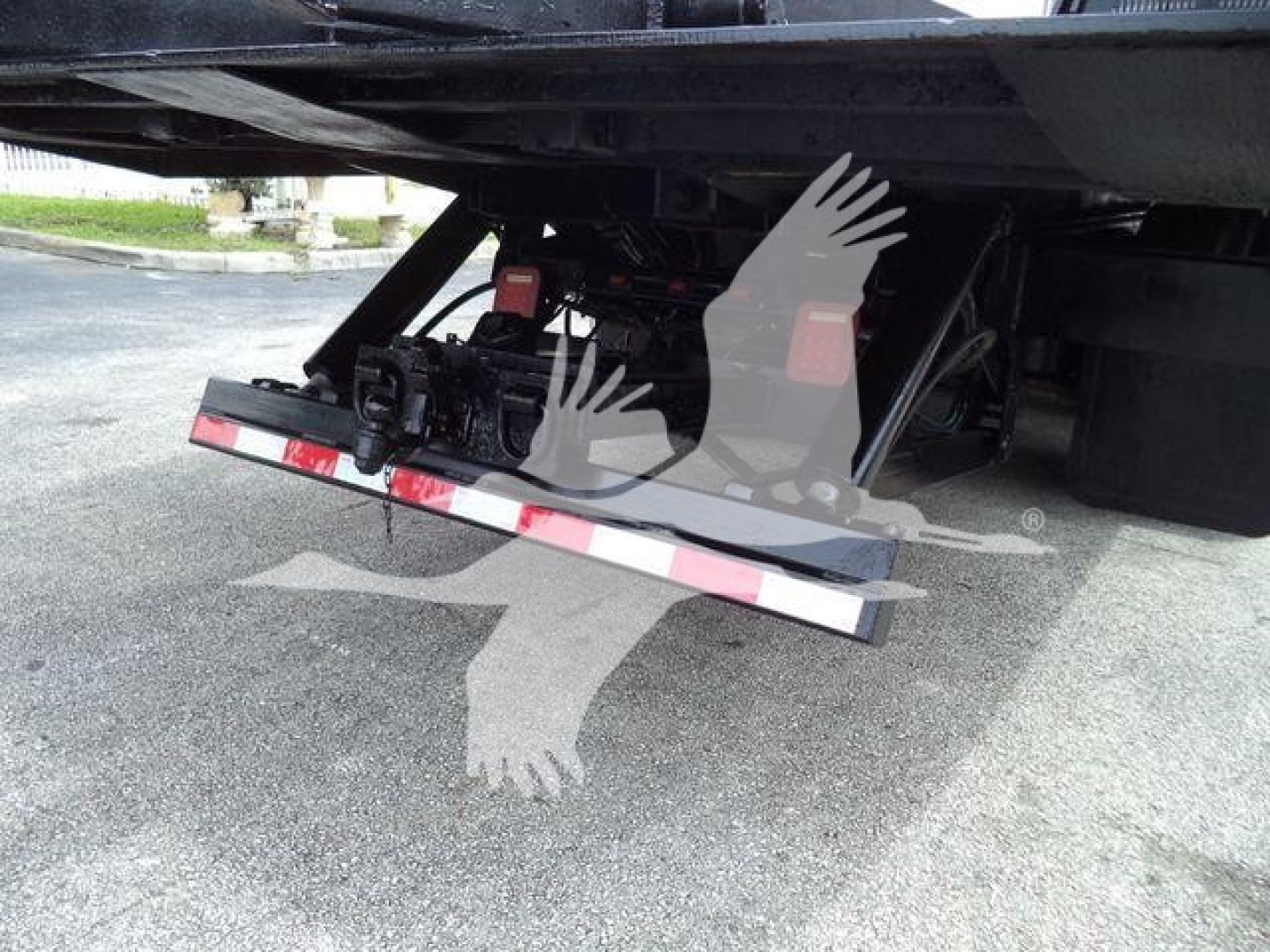 Freightliner M2 106 roll-off truck undercarriage showing tailgate and hydraulic components.