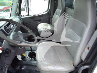 Truck cab interior of a 2006 Freightliner M2 106 showing driver seat, passenger seat, steering wheel, and dashboard from the doorway viewpoint.