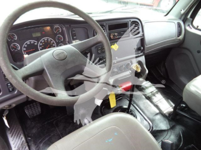 Freightliner M2 106 cab interior showing steering wheel, dashboard gauges, center console, and gear shifter.
