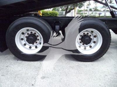 Dual rear axles on Freightliner M2 106 chassis showing white steel wheels and dual tires with frame Rails and suspension components visible.