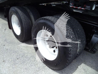 Rear dual wheels of a Freightliner M2 106 roll-off truck showing heavy-duty tires and white rims.