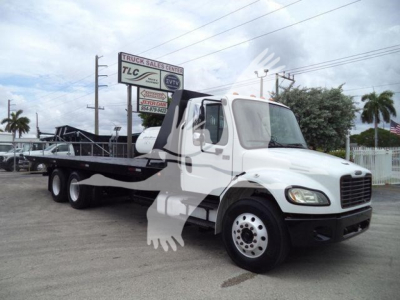 Freightliner M2 106 roll-off truck in white with flatbed, side view showing cab and dual rear wheels.