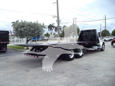Freightliner M2 106 roll-off truck viewed from rear-side, showing trailer bed with hydraulic mechanism and dual rear axles.