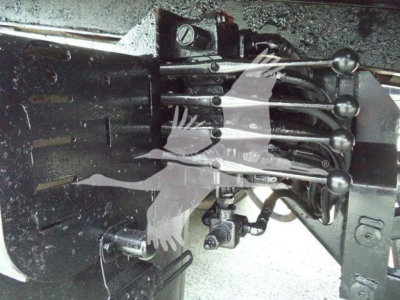 Freightliner M2 106 roll-off truck rear linkage levers and hydraulic components visible.