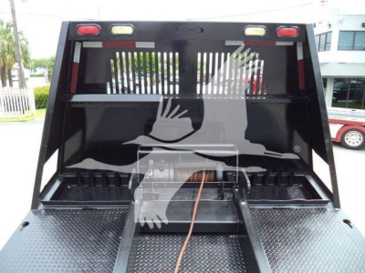 Rolloff truck rear view showing loading bed and compartment on Freightliner M2 106 with metal diamond plate surface.